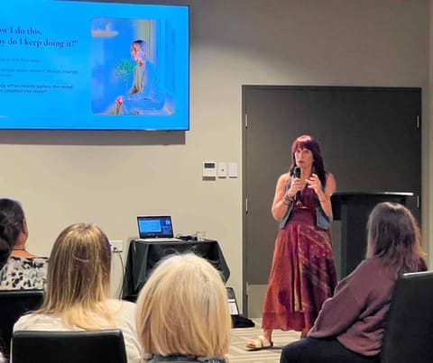 Dawn speaking at a workshop, microphone in hand, the room listening